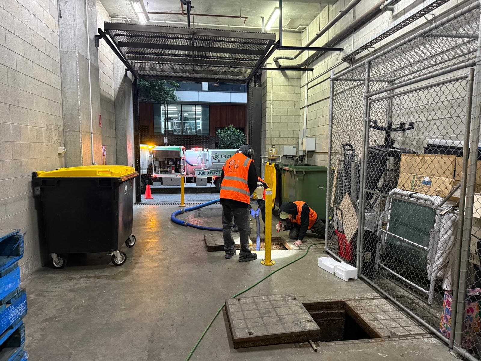Liquid Vac crew carrying out vacuum recovery work inside a loading bay
